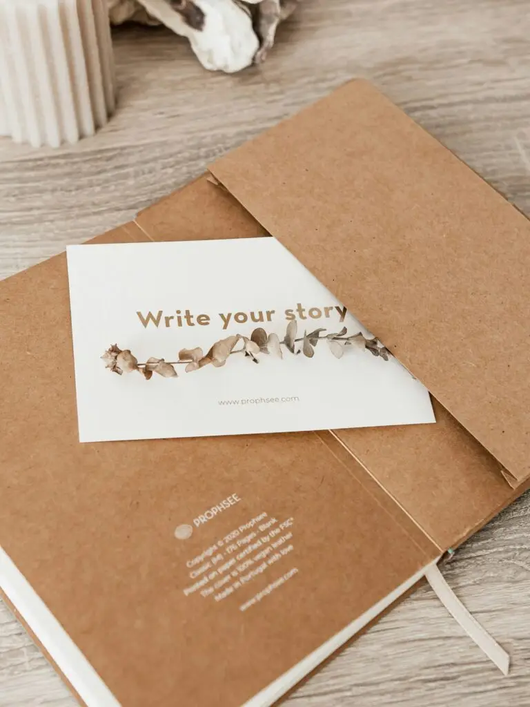 a journal with a card inserted that says write your story